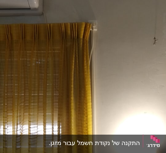 שקע חשמל על קיר ליד וילון צהוב